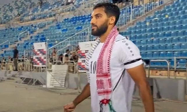 لاعب المنتخب الأردني يرتدي وشاح تامنا مع فلسطين